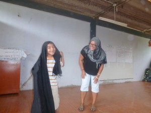 tina teaching eduardo the steps to wrapping the hijab.